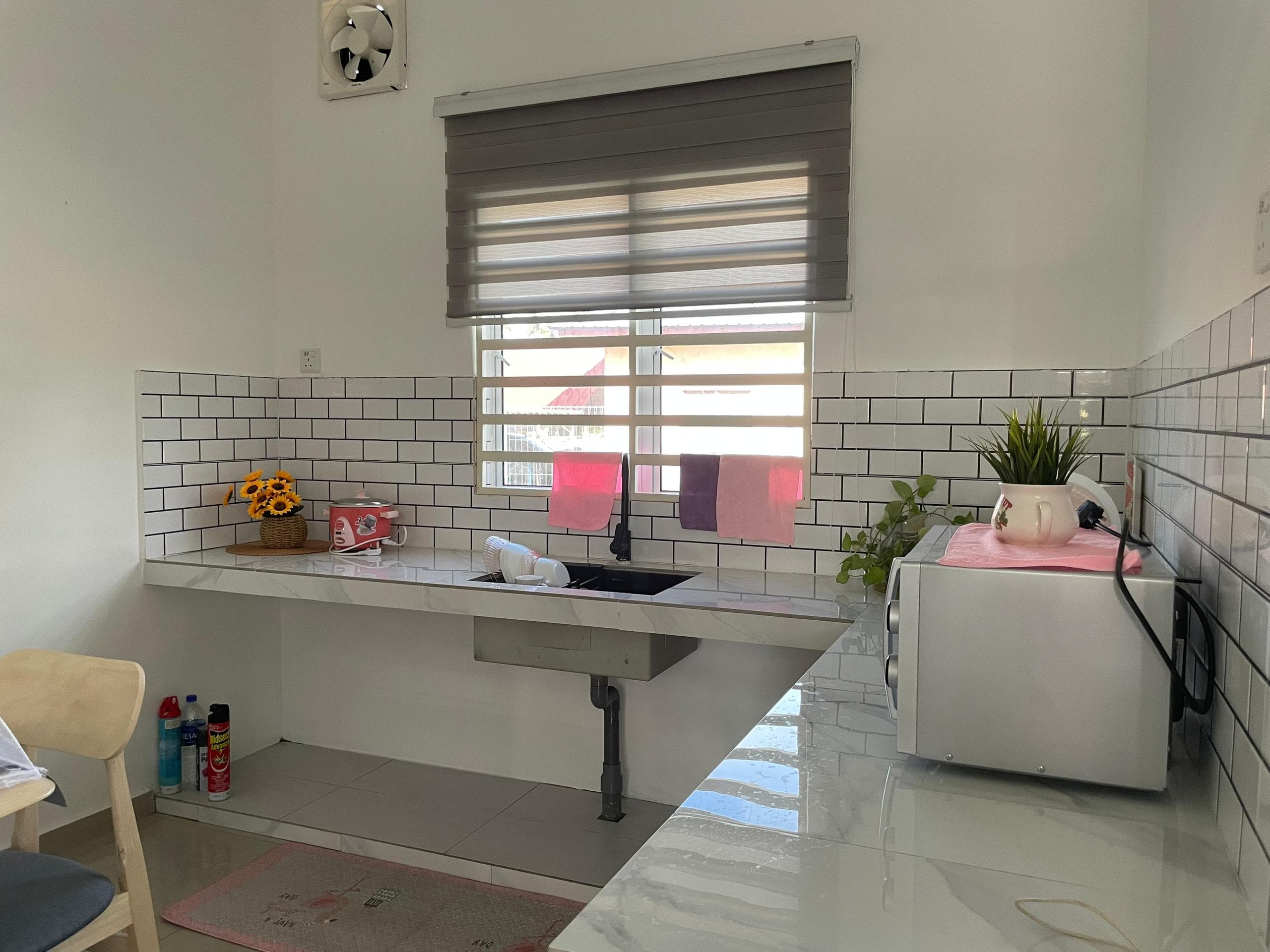 Dapur kemas dengan sinki dan meja penyediaan di Homestay Lekir